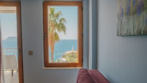 A room with a view of the sea, a palm tree, and a purple sofa. - Hotel No37 (Kas)