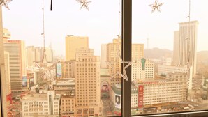 Une vue sur la ville à travers une fenêtre décorée d’étoiles.