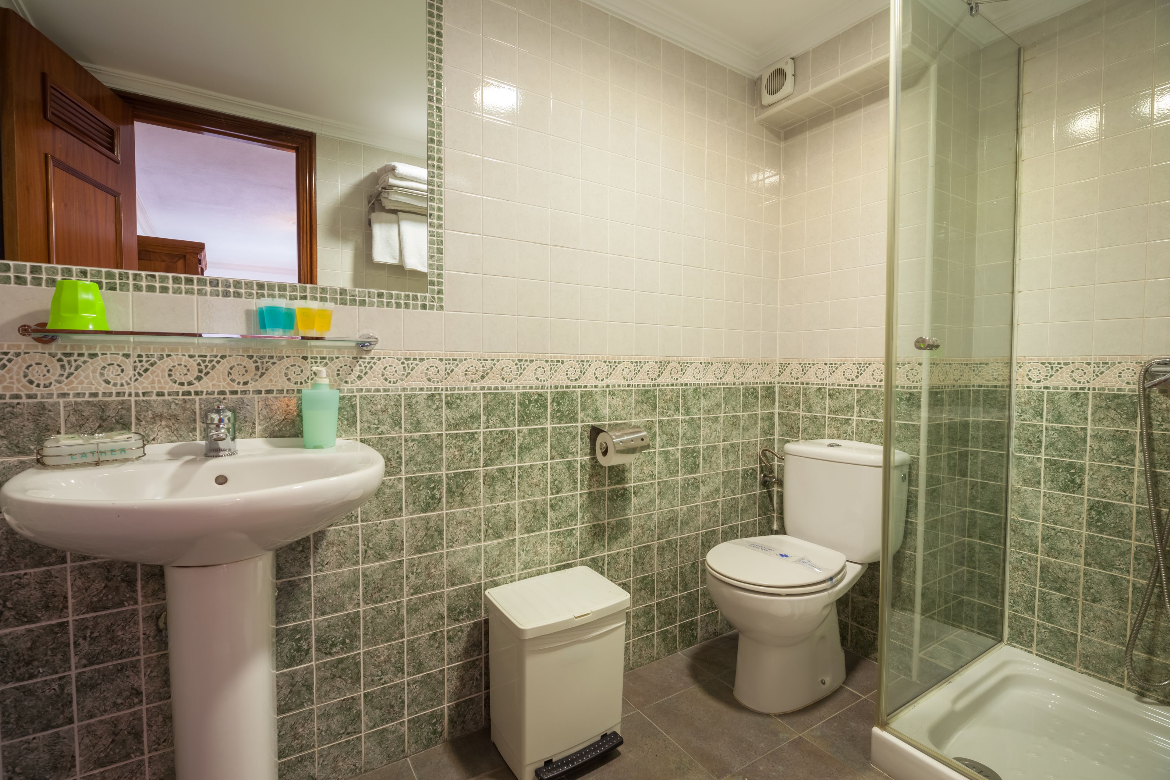Un baño con lavamanos, inodoro y ducha.