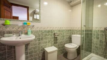 Un baño con lavamanos, inodoro y ducha.
