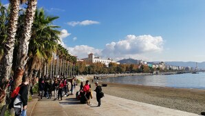 A waterfront promenade with palm trees, a river, and buildings in the background. - B&B Dei Mercanti (Salerno)