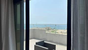 Een balkon met uitzicht op zee en een strand.