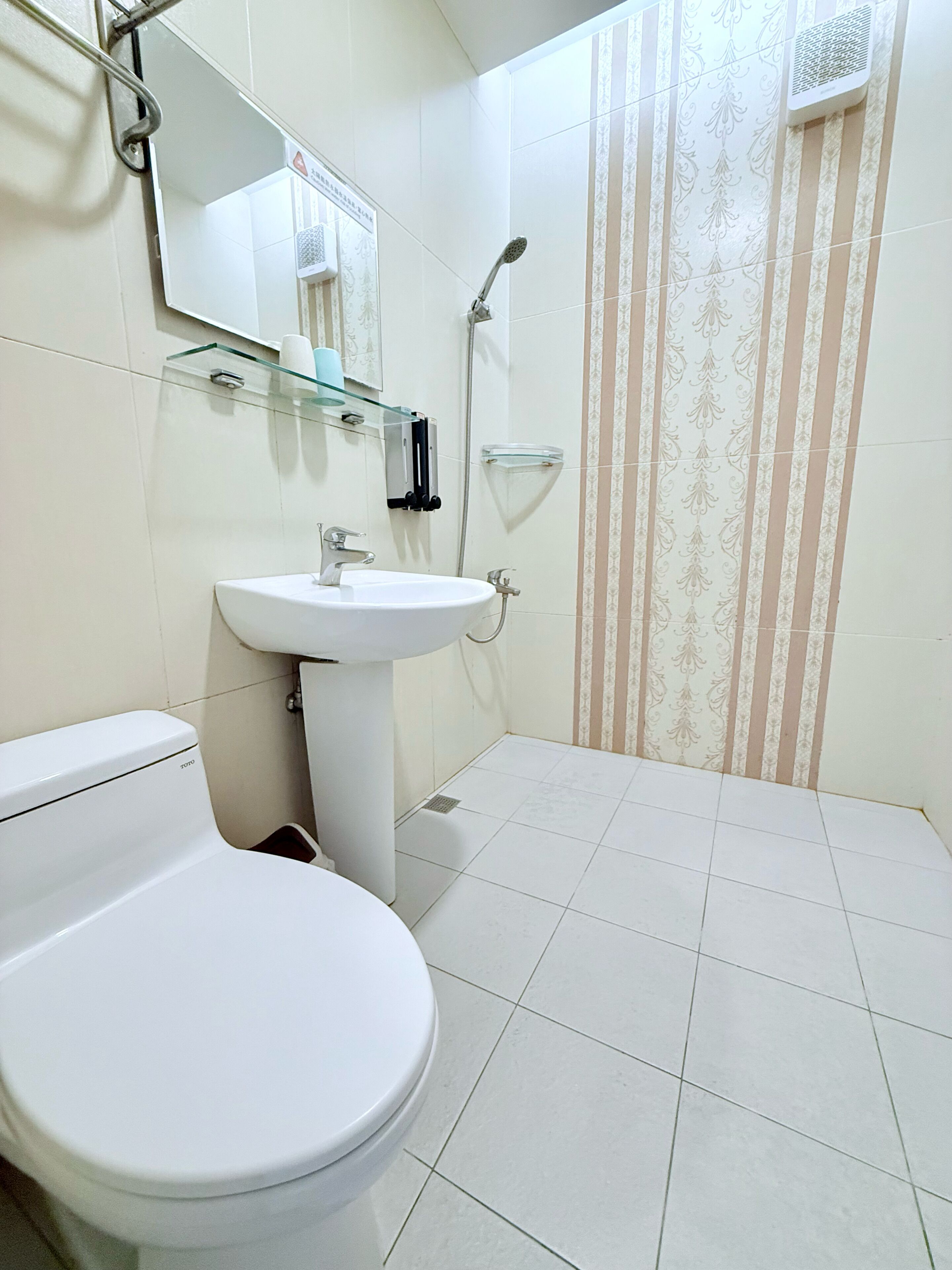 A bathroom with a toilet, sink, and shower.