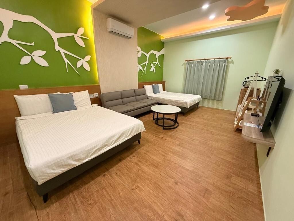 A hotel room with a bed, sofa, and a small table.