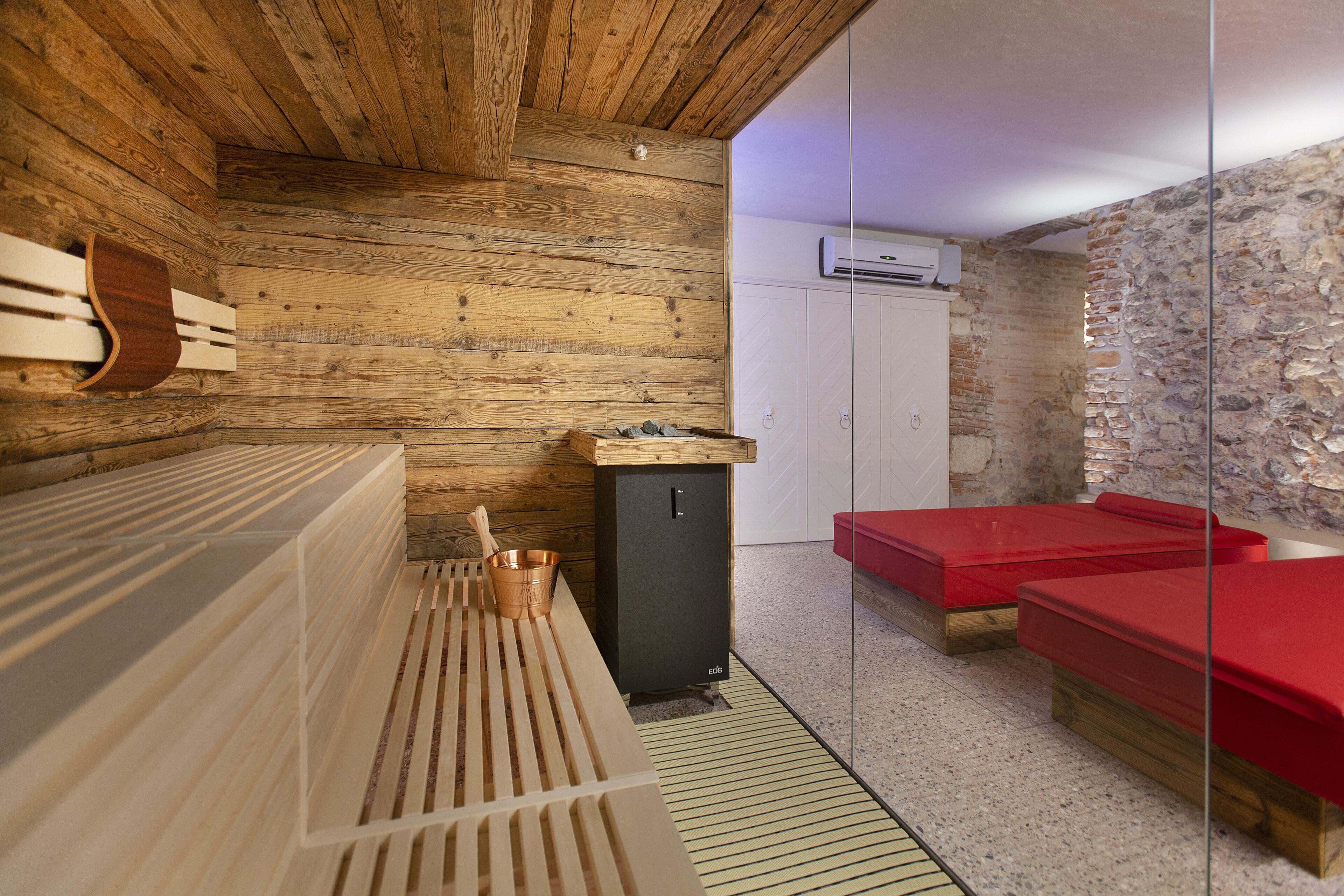 Ein Saunaraum mit Holzwänden, einer Massageliege und einem kleinen Schrank.