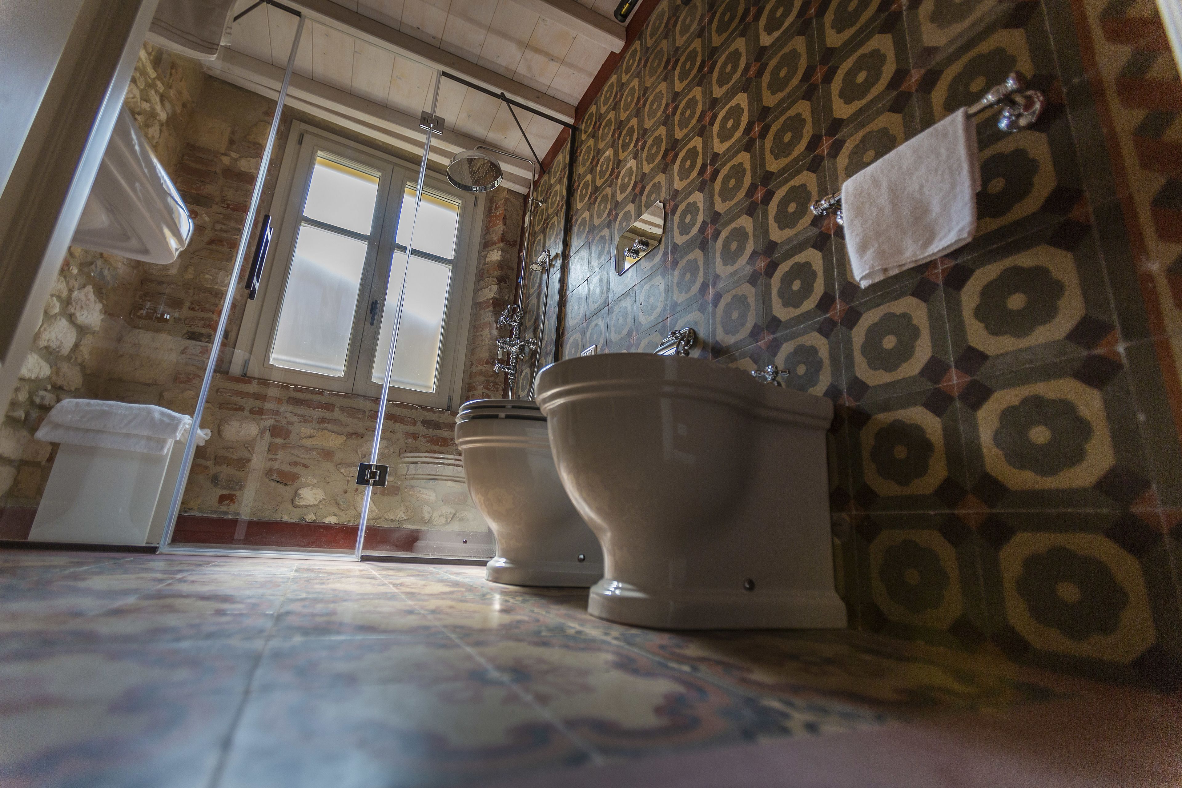 Un baño con dos inodoros, ducha y lavamanos.