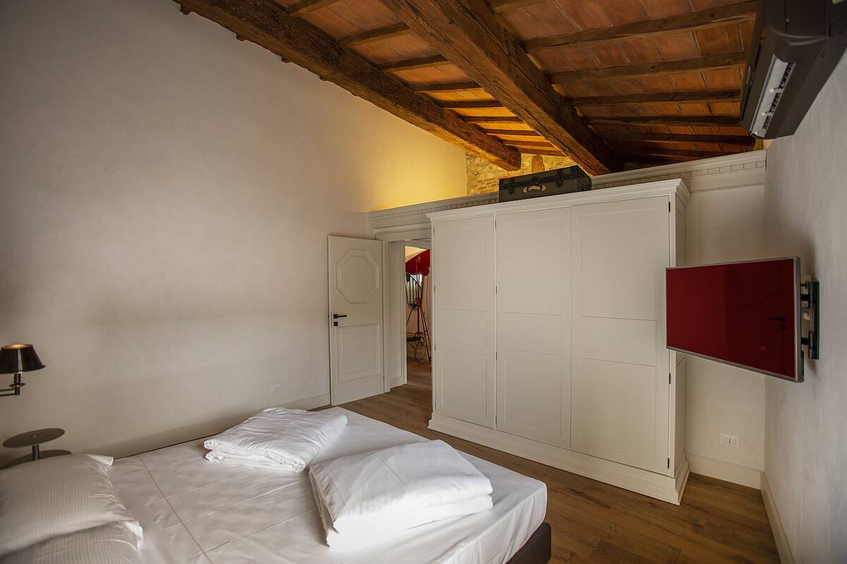 A bedroom with a bed, wardrobe, and a red cabinet.