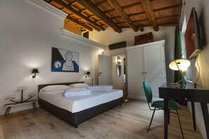 Un dormitorio con cama, mesitas de noche, escritorio y una silla.