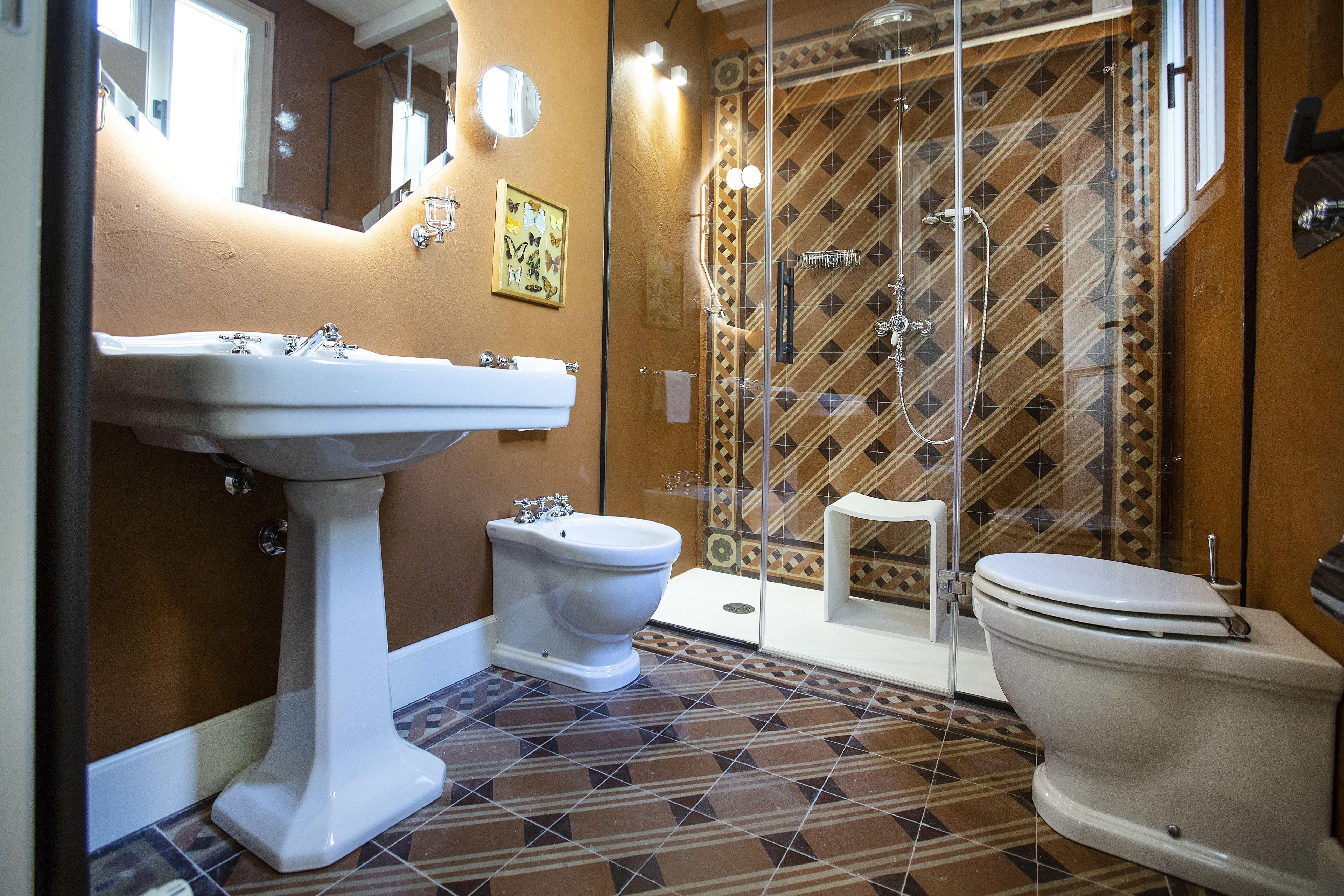 Une salle de bain équipée d’un lavabo sur colonne, de toilettes et d’un espace douche.