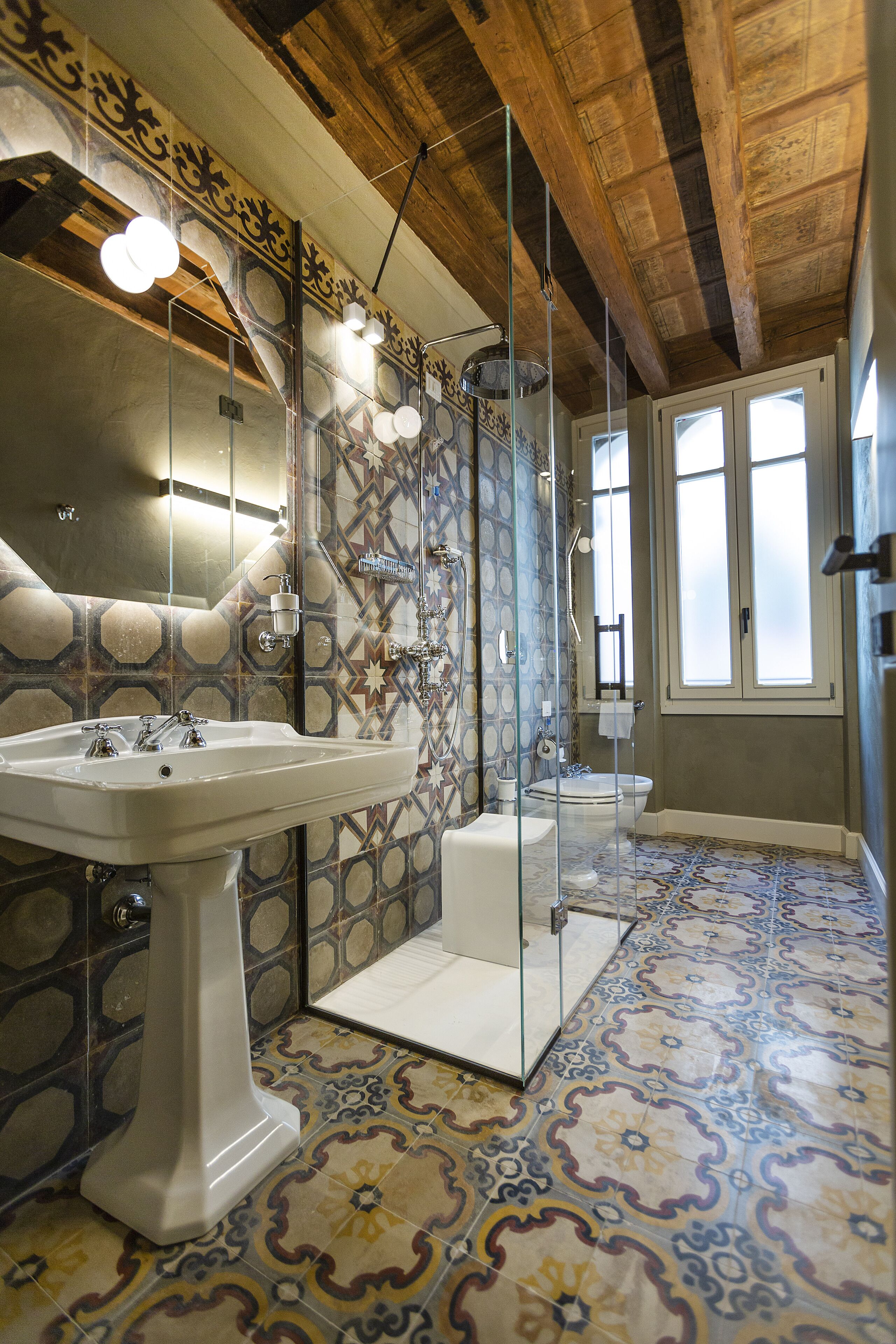 A bathroom with a large sink, a toilet, and a shower area.