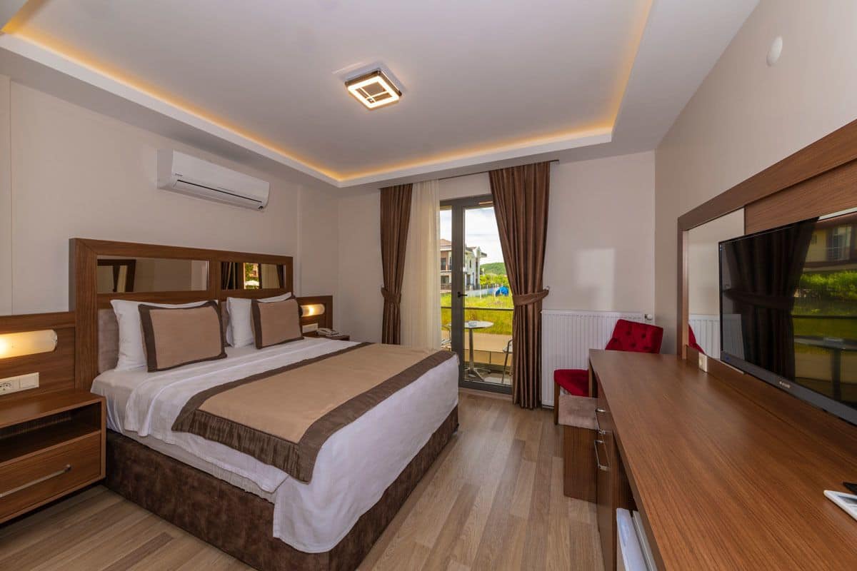 Une chambre d’hôtel avec un grand lit, un bureau, une télévision et une vue sur l’extérieur.