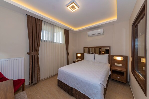 A hotel room with a bed, bedside tables, an air conditioning unit, and a window with curtains. - Agva Palas Hotel (Sile)