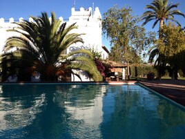 Una piscina al aire libre, tumbonas