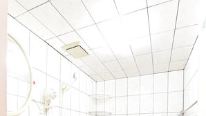 A bathroom with white tiled walls, a pink floor, a white sink, and a toilet with a glass shower enclosure. - YoYo MaAn B&B (Liuqiu)