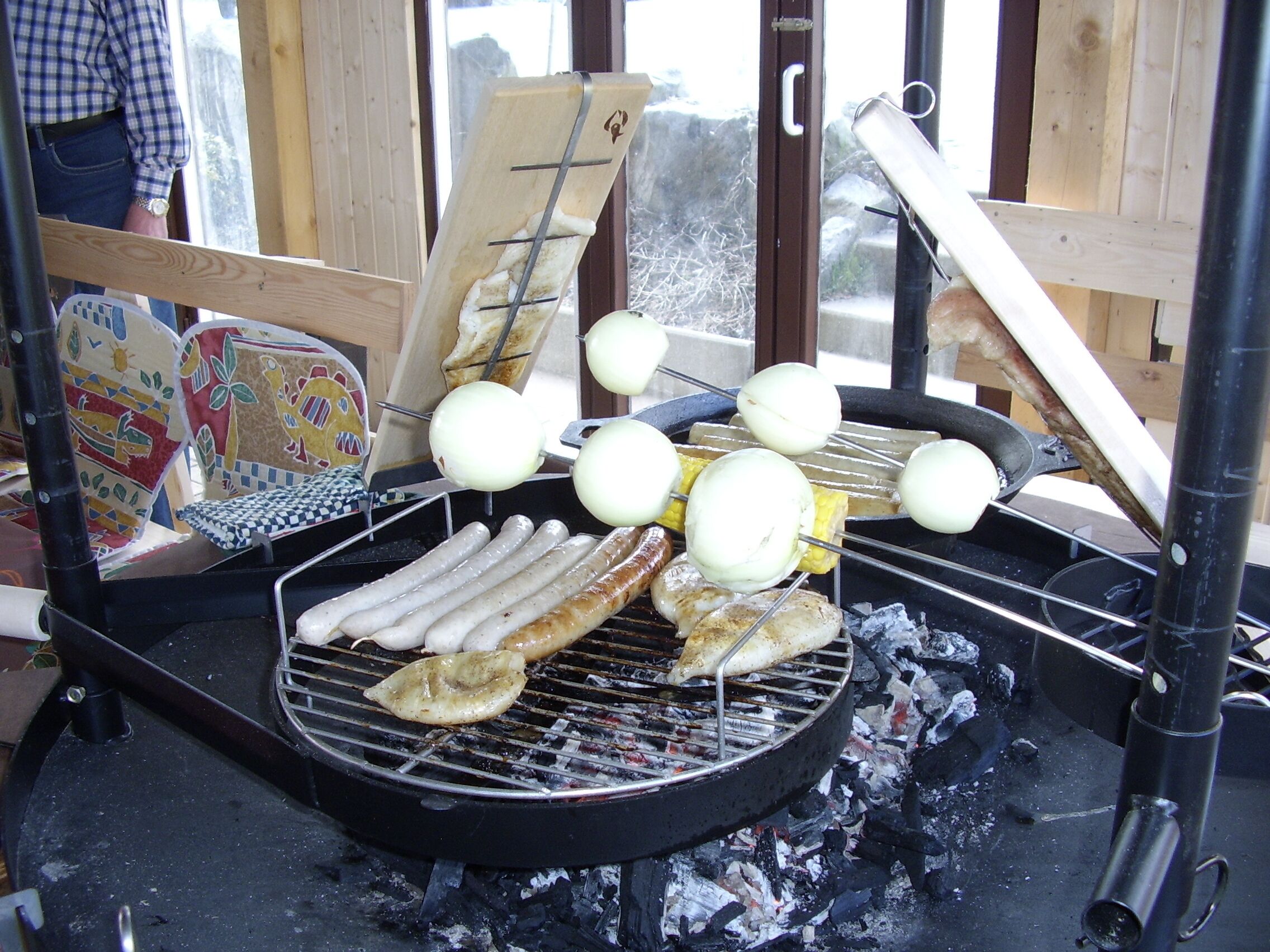 Ein Grill mit Würstchen und Spießen mit Fleisch und Gemüse.
