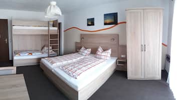 Ein Schlafzimmer mit Etagenbett, einem Einzelbett, einem Kleiderschrank und einer Pendelleuchte.