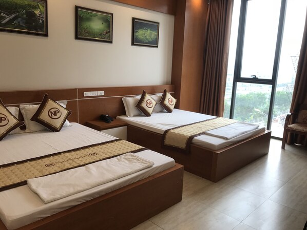 A hotel room with two beds, a nightstand, and a window with a view. - Ninh Phong Hotel (Yen Trung)