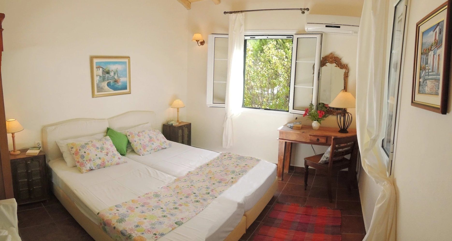 A bedroom with a bed, a desk, a chair, a window with curtains, a lamp, and a painting on the wall.