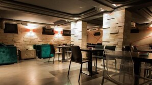 Un interior moderno con una variedad de opciones de asientos, incluyendo sofás y sillones, un suelo de baldosas y una pared de acento de piedra.