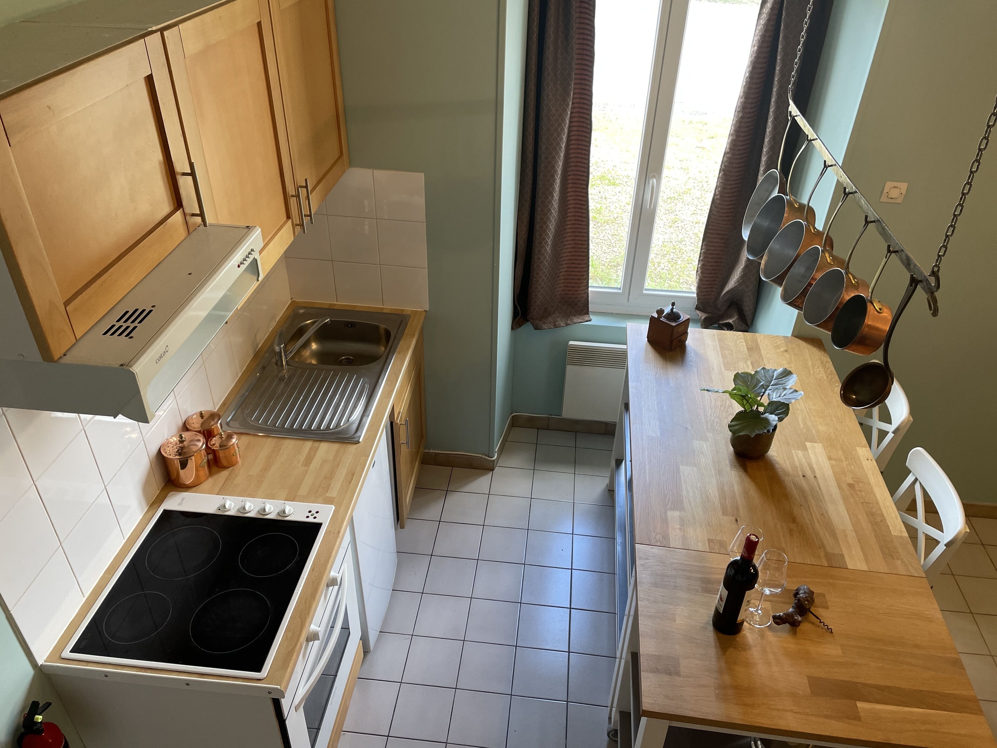 A modern kitchen with a stove, sink, and wooden cabinets.