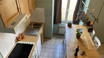A modern kitchen with a stove, sink, and wooden cabinets.