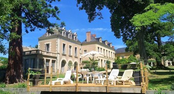 A large, historic building with a balcony and outdoor seating area.