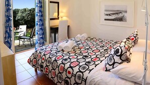 Une chambre d’hôtel avec un lit, un bureau, une chaise et une vue sur l’extérieur.