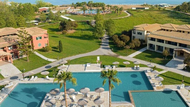 Un complexe hôtelier doté de plusieurs piscines, de palmiers et offrant une vue sur l’océan.