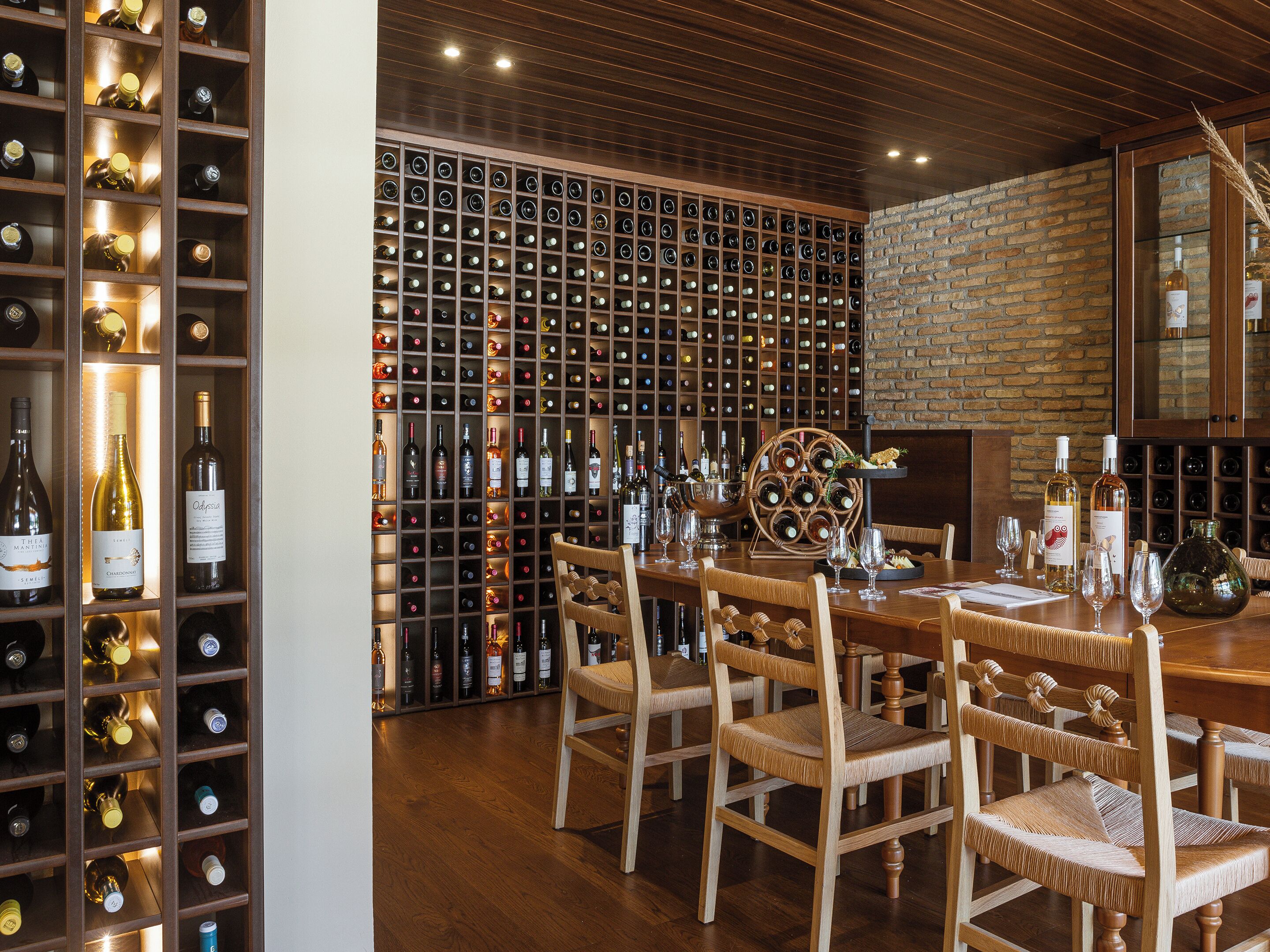A wine cellar with wooden shelves and a brick wall.
