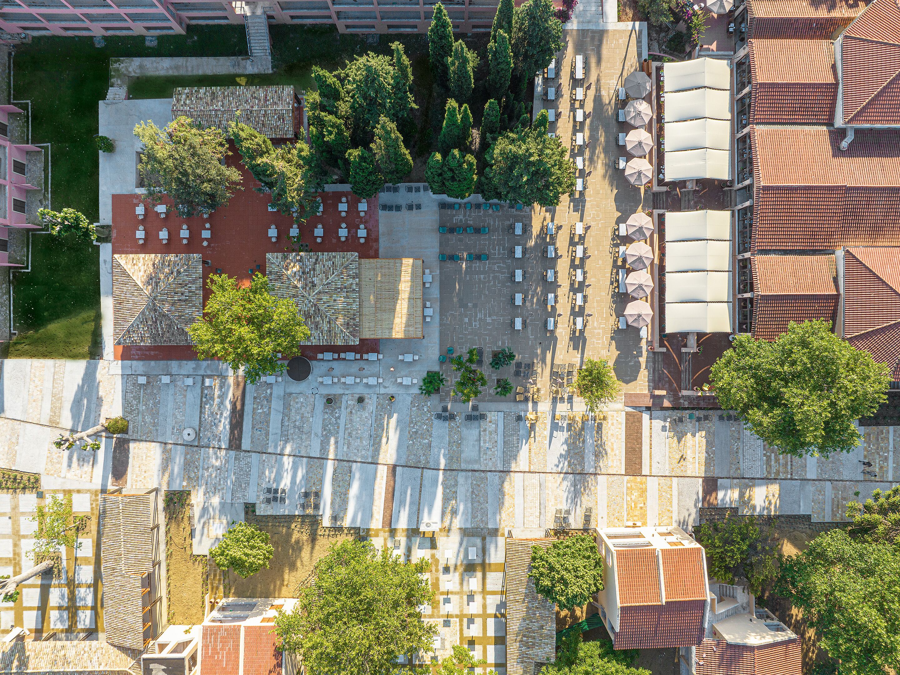 An aerial view of a courtyard with outdoor seating, trees, and a mix of building styles.