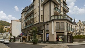 Un immeuble d’angle doté de nombreux balcons, d’une enseigne bien visible portant l’inscription « ATLANTIC » et d’une devanture de magasin facilement reconnaissable.