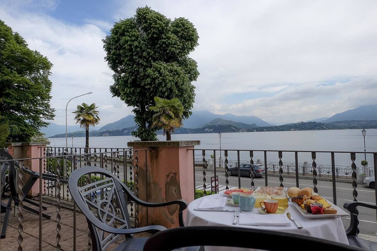 Une table dressée avec des aliments pour le petit-déjeuner, donnant sur un lac avec des montagnes en arrière-plan.