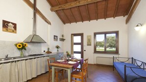 Cozinha com mesa, cadeiras, cama e janela com vista.