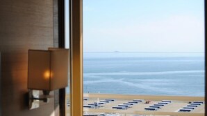 A view of the ocean through a window with a lamp on the left. - Hotel Capri & Residence (Camaiore)