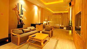 Una sala de estar moderna con un sofá, sillones, una mesa de centro y un televisor.