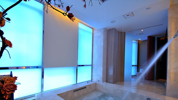 Un baño moderno con una bañera grande, ventanas con vidrio esmerilado y zona de ducha.