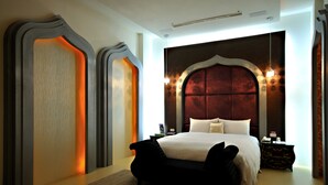 Un dormitorio moderno con una cama grande, un cabecero oscuro y un diseño de pared original.