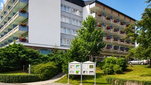A multi-story hotel with balconies, a green lawn, and a clear sky. - Spa & Wellnesshotel Bad Alexandersbad (Bad Alexandersbad)