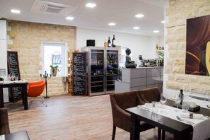 Un interior de restaurante moderno con paredes de piedra, una zona de bar y un área de asientos.