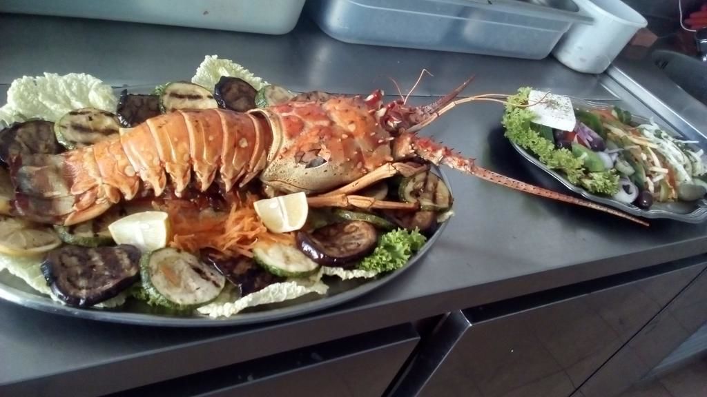 Una bandeja con mariscos, incluyendo langosta, mejillones y verduras.