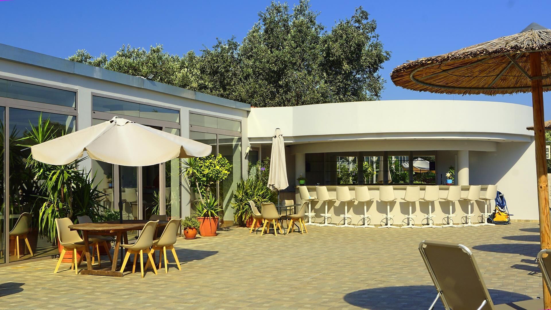 Eine Terrasse im Freien mit Essbereich, Sitzgelegenheiten und einer Bar.