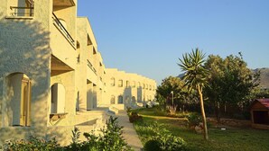 A building with a series of arches and a pathway leading to a courtyard. - Saint George Resort (Rhodes)