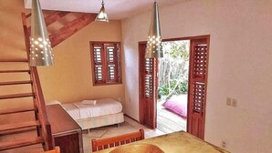 A room with a wooden table, a wooden chair, a bed, and a staircase. - Sunset Jeri Flat (Jijoca de Jericoacoara)