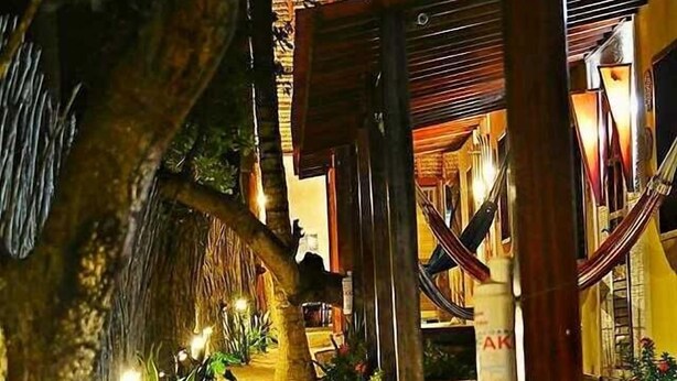 A pathway leading to a building with a thatched roof and wooden beams. - Sunset Jeri Flat (Jijoca de Jericoacoara)
