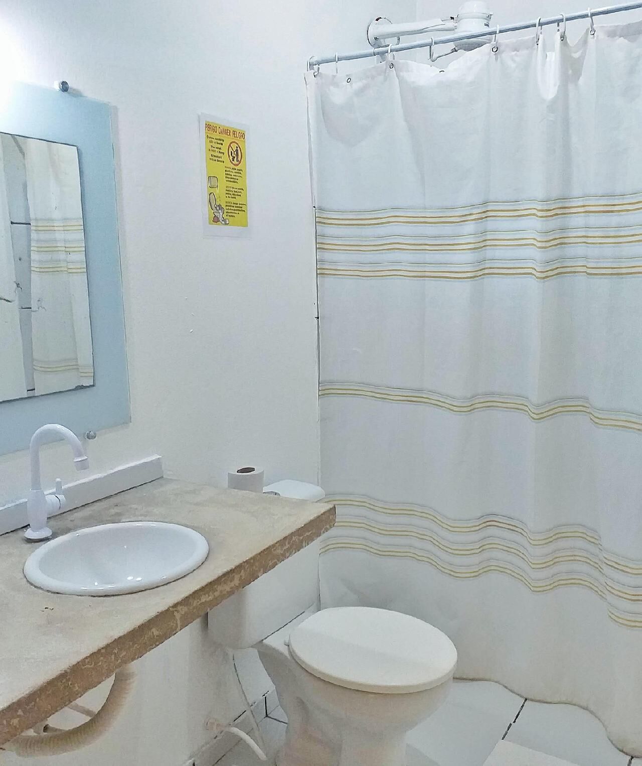 Ein Badezimmer mit Waschbecken, Toilette und Duschvorhang.