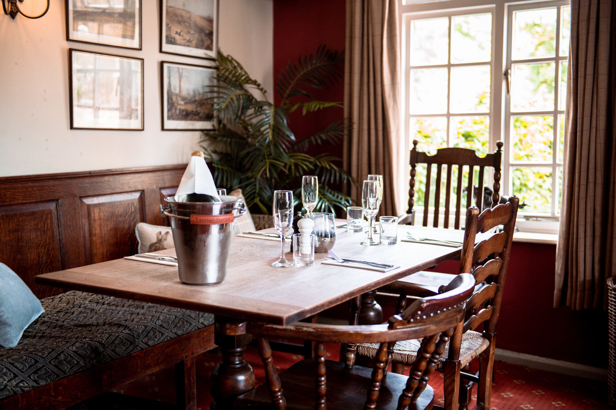 A dining table set with wine glasses, a bucket, and a candle.