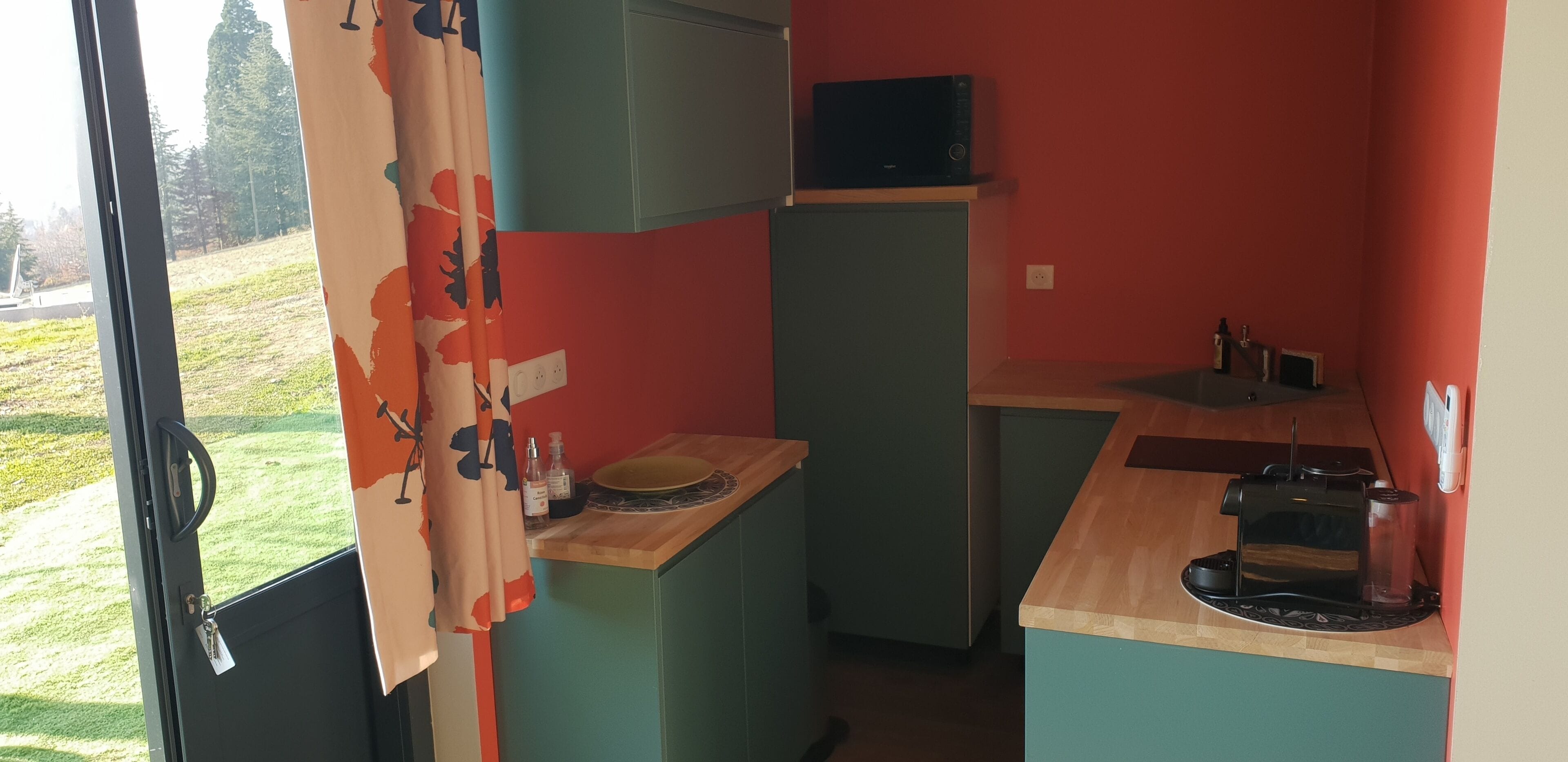 A compact kitchen with a microwave, coffee maker, and a small sink.