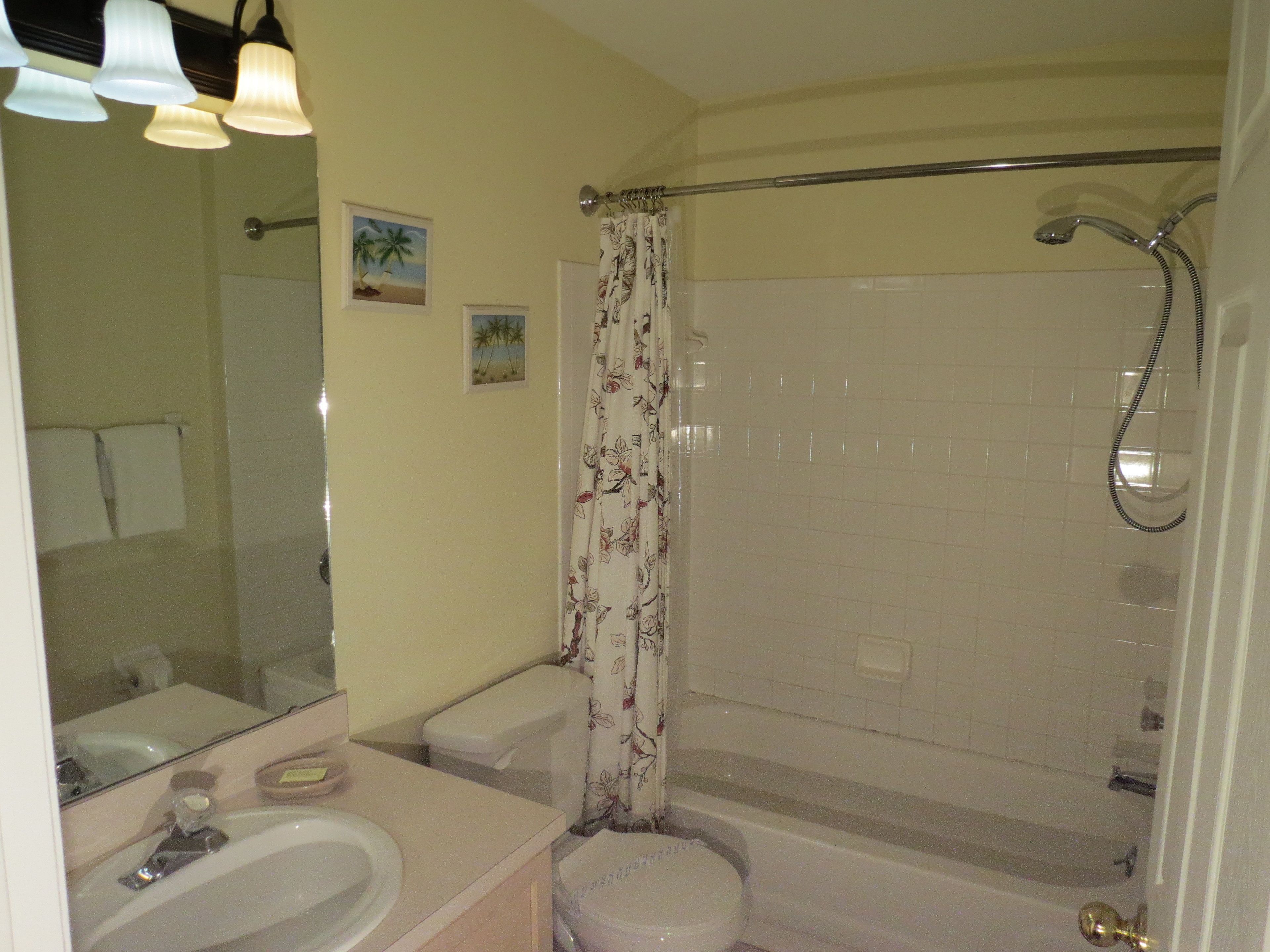 A bathroom with a bathtub, toilet, sink, and shower.