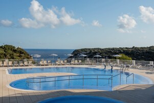 Una piscina al aire libre, tumbonas