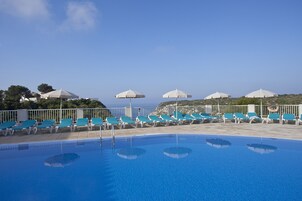 Una piscina al aire libre, tumbonas